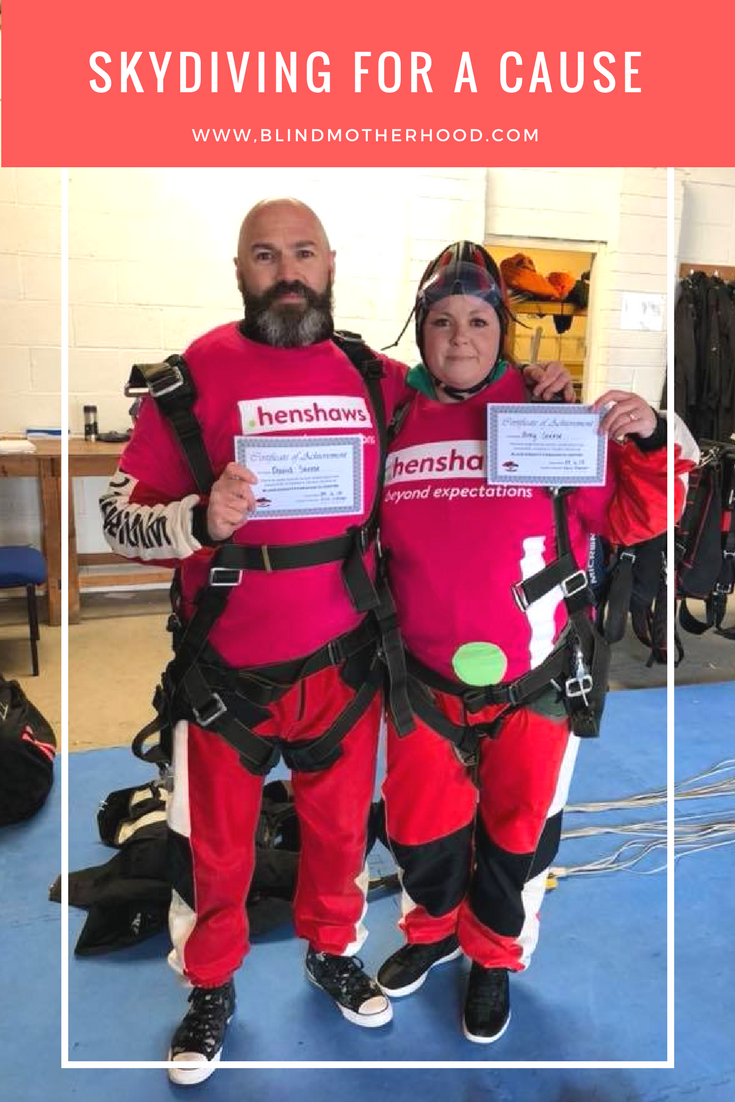 ID: Blind Poet, Dave Steele, stands with is wife, Amy, in Henshaws skydiving suits celebrating their leap for the U.K. charity.