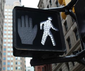 Crosswalk with hand and person figure.