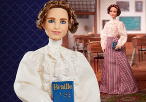 Close up of Helen Keller Barbie face holding braille book.