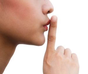 Profile of women's face with her finger to her lip.